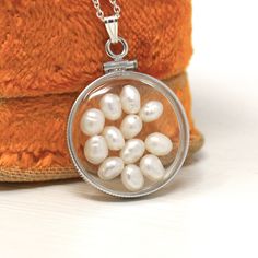 "Mermaid inspired handcrafted brand new sterling silver baroque pearl shaker locket! This statement pendant is nickel sized with coin style bezels, and clear lucite covers. The round charm hangs from a brand new sterling silver chain, and is filled with 12 baroque pearls. An aquatic style piece of brand new jewelry, featuring June's birthstone! ERA - New METAL / MATERIAL - Sterling silver locket, sterling silver chain, lucite clear covers, 1 screw (can be opened and closed with a small screwdriv