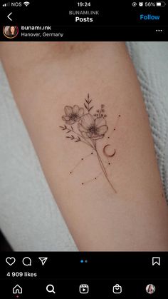 a small flower tattoo on the right arm and shoulder, with stars in the background