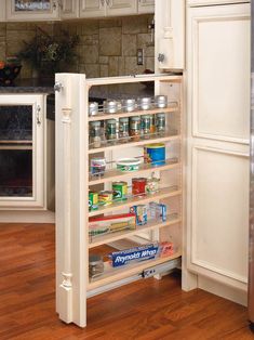 an open cabinet in the middle of a kitchen with lots of food items inside it