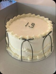 a large white cake with the number thirteen on it's side in a box