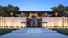 an entrance to a modern home with lights on the side and trees in the background