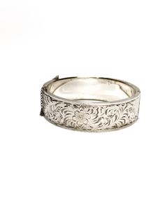 Featured is a Floral Engraved Sterling Silver Bracelet  We just love this beautiful bracelet crafted of sterling silver with a floral engraved front panel.  The bracelet is signed Forstner Sterling.  Forstner got their start in Irvington NJ in 1922, changing names to Forstner Jewelry Manufacturing Corp. in 1978. The bracelet is a hinged bangle style with a unique hidden clasp.  The bracelet opens by gently sliding the left panel (the floral side) upward and the right side downward, then pulling Classic Engraved Sterling Silver Bangle Bracelet, Classic Etched Bracelet Jewelry, Engraved Sterling Silver Elegant Bracelet, Classic Engraved Sterling Silver Bracelet, Elegant Engraved Sterling Silver Bracelet, Elegant Etched Bangle Bracelet, Elegant Engraved Sterling Silver Bangle, Elegant Stamped 925 Silver Bangle, Elegant Stamped 925 Bangle Jewelry