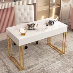 a white table with gold legs and a magazine on it in front of a pink chair