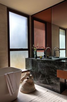 a bathroom with a sink, mirror and large bathtub in the middle of it