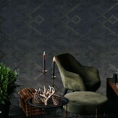 a chair and table in front of a wallpapered room with a candle on it