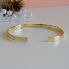 "Looking for the new daughter in law gift? Our \"Welcome to the family\" bracelet makes a great memento from Mother/Father in Law. - Laser engraving up to 90 characters on each side  - Coated with 22K gold and the thickness of the gold layer is 0.5 microns  - Text, coordinates, numbers or handwriting outside and inside the cuff  - Approximately 5mm wide, 1.2 mm thick - Laser engraved - the engraving is burned into the material using a laser beam.  SIZES: This is the length of the metal, not incl Engraved Bangle Bracelet For Wedding, Engraved Name Bracelet For Anniversary And Mother's Day, Engraved Name Bracelet For Anniversary Mother's Day, Engraved Name Bracelet For Mother's Day Anniversary, Engraved Name Bracelet For Anniversary, Mother's Day Gift, Adjustable Heirloom Bracelets For Anniversary, Engraved Gold Heirloom Bracelet For Wedding, Engraved Heirloom Gold Bracelet For Wedding, Heirloom Gold Bracelet Engraved For Wedding