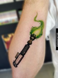 a man's arm with a green ink tattoo on it and a pipe coming out of it