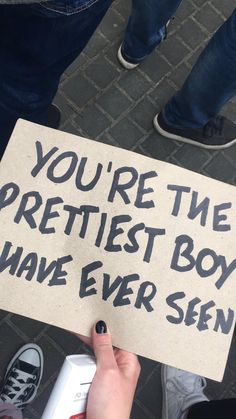 someone holding a sign that says you're the prettiest boy i have ever seen