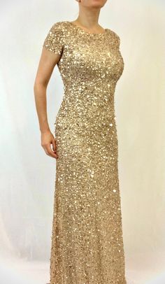 a woman in a gold sequin dress posing for the camera with her hands on her hips