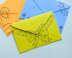 four envelopes with drawings on them sitting next to each other, one has a bow