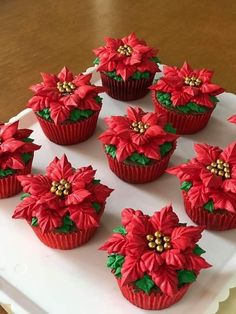 red cupcakes decorated with poinsettis on a white tray