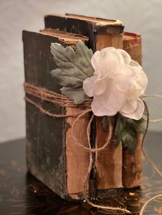 an old book with a flower on it sitting on a table next to some string