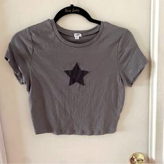 Garage Grey Semi-Crop T-Shirt With Star Appliqu. Size Large. Never Worn. Casual, Punk Rock, Goth, Grunge, Biker, Moto, Figure Flattering, Trendy. Gray Goth Aesthetic, 90s Fashion Grunge Women, Trendy Summer T-shirt With Star Patch, Graphic Tee With Star Logo For Summer, Crew Neck Tops With Star Logo For Summer, Summer Cotton T-shirt With Star Patch, Grunge Style Star Print T-shirt For Summer, Trendy Fitted Tops With Star Print, Casual Summer Tops With Star Logo