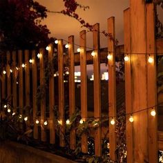 a wooden fence with lights on it