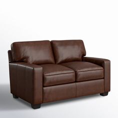 a brown leather couch sitting on top of a white floor