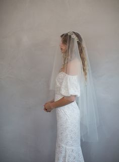 a woman in a wedding dress with a veil on her head