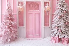 pink and white christmas trees in front of a pink door with snow on the ground