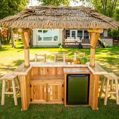 an outdoor kitchen made out of pallet wood with a tiki bar and stools