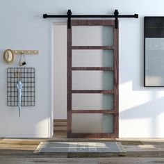 an open door in a white room next to a wall clock and coat rack with hooks