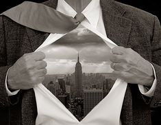 a man in a suit opening his shirt to reveal the cityscape