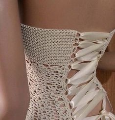 a close up of a woman's white dress with laces on the bottom