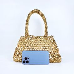 Featuring a hollow exterior adorned with intricate circular patterns, this bag exudes a unique and modern aesthetic that captures attention wherever you go. Its versatile design seamlessly complements a wide range of outfits, making it perfect for various occasions. Crafted from premium quality materials, the Lustrous Handbag exudes luxury and durability, ensuring it stands the test of time. Now available in gold and silver. Chic Evening Satchel For Summer, Elegant Evening Satchel For Summer, Versatile Gold Shoulder Bag With Top Handle, Versatile Gold Top Handle Shoulder Bag, Trendy Gold Top Handle Bucket Bag, Versatile Gold Shoulder Bag With Detachable Handle, Elegant Gold Bucket Bag With Large Capacity, Modern Gold Satchel With Large Capacity, Elegant Summer Hobo Bag