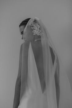 the back of a bride's dress is shown with her veil draped over her head