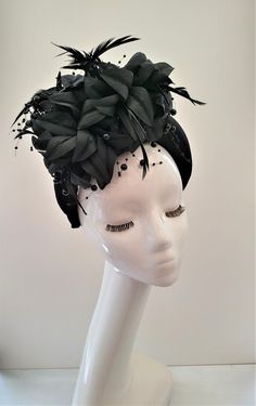 Presenting a stunning beautiful black fascinator with feathers and beading, attached via a  black velvet  covered headband  which is 4 cms in width at the widest part approximately and 3.5 cms in height (the headband) the feather flower design is much higher above the design. Perfect for special events.  If you would like the design customising at all, or an alternate colourway please get in touch with me and I will be delighted to help.   Follow us on instagram: https://www.instagram.com/designbyhummingbirdofficial/ Adjustable Crown-shaped Fascinator For Party, Black Crown Headband For Party, Adjustable Crown Headpiece For Evening, Black Party Headpiece With Matching Headband, Black Round Crown Headpieces For Wedding, Elegant Adjustable Headpieces For Costume Party, Elegant Mini Hat Headband For Costume Party, Elegant Mini Hat With Headband For Costume Party, Black Event Headband