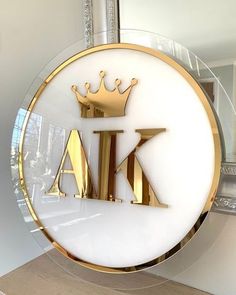 a glass sign with the letters k and a crown on it in front of a mirror