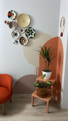 an orange chair sitting next to a potted plant on top of a wooden table