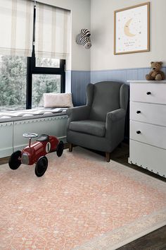 a child's room with a toy car on the rug