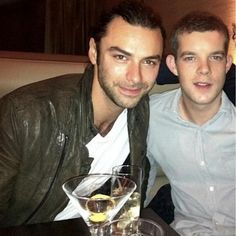 three men sitting at a table with drinks in front of them