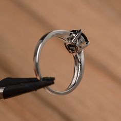 It is a natural black spinel ring. The main stone is 7mm*7mm round cut, weight about 1.65 carats. The basic metal is sterling silver and plated with rhodium. To change the metal to a solid gold (white/rose) or platinum is also available, please ask for a quotation if you want. You can also go to my shop Home for more elegant rings: https://www.etsy.com/shop/godjewelry?ref=hdr_shop_menu More black spinel rings: https://www.etsy.com/shop/godjewelry?ref=seller-platform-mcnav&section_id=21680005 Modern 14k White Gold Round Jewelry, 14k White Gold Open Ring With Brilliant Cut, Diamond Solitaire Open Ring Jewelry, Minimalist Cubic Zirconia Rings With Tension Setting, Minimalist Cubic Zirconia Round Band Jewelry, Minimalist Jewelry With Prong Setting For Promise, Minimalist Cubic Zirconia Jewelry, Formal Stainless Steel Round Band Jewelry, Sterling Silver Jewelry With Brilliant Cut For Promise Ring