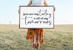 a woman holding a sign that says you are my today and all of my tomorrows