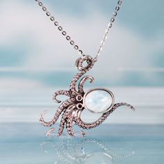 This charming octopus Larimar pendant necklace captures the beauty and mystery of the sea in solid sterling silver and aquamarine Larimar. The sterling silver cable chain fastens securely while the solid 925 sterling silver octopus body forms the perfect setting for the lovely Larimar stone head that evokes the ocean depths. Wear this beautiful and unique octopus necklace to channel the magic of the sea and complement your love of Larimar jewelry and sea animal-inspired designs. The necklace mak Octopus Head, Body Forms, Octopus Necklace, Octopus Pendant, Unique Pendant Necklace, Larimar Jewelry, Larimar Pendant, Larimar Stone, Sea Animal