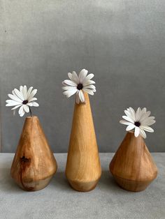 three wooden vases with white flowers in them