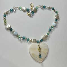 beautiful beaded necklace for the summer; total mermaid vibes; looks even more beautiful in the sun! (seashell heart, czech glass beads, faux pearl beads, crystal beads, glass, acrylic) Heart Beads Necklace For Beach, Heart-shaped Beaded Necklaces For The Beach, Beaded Abalone Shell Necklaces For Gift, Abalone Shell Beaded Necklaces As Gift, Heart-shaped Colorful Beads Jewelry For Beach, Abalone Shell Beaded Necklace For Gift, Handmade Heart-shaped Beach Necklaces, Handmade Heart Necklace For Beach, Handmade Heart-shaped Necklace For The Beach