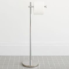 a toilet paper holder with a roll of toilet paper on it's side and a white wall in the background