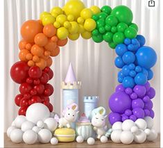 there is a rainbow arch with balloons on the top and an unicorn figurine below