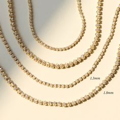 A shining tennis necklace, made of 100% recycled 14k gold and recycled brilliant cut diamonds. Now available in two carat weights — our classic slim bracelet, and a new larger, starrier size. Our strong, discreet clasp is cleverly and luxuriously set with diamonds. Equally suited to be worn at midday, and past midnight. This is the one you’ve been waiting for. 14k Yellow Gold Tennis Necklace, Minimalist Cubic Zirconia Tennis Necklace, Timeless Tennis Necklace With Round Cut For Everyday Luxury, Dainty Tennis Necklace With Brilliant Cut, Dainty Round Brilliant Cut Tennis Necklace, Timeless Tennis Necklace With Diamond Accents Gift, Timeless Tennis Necklace With Vvs Clarity, Minimalist Diamond Tennis Necklace For Anniversary, Luxury Tennis Necklace With Lab Grown Diamonds