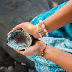 The Learn to Surf Howlite Bracelet is made with semi-precious stones and an adjustable cotton cord with three size options. Adjust to your perfect fit and snip off any excess cord. Colors: Cream White, Turquoise, Silver, Cream Cord Materials: Howlite, Turquoise, Coconut Button, Cotton Cord Length: 6.5" (first closure), 8.5" (last closure) Handmade by female artisans in Thailand. Spiritual Hand Wrapped Turquoise Friendship Bracelets, Spiritual Hand-wrapped Turquoise Friendship Bracelets, Spiritual Turquoise Hand Wrapped Friendship Bracelets, Adjustable Turquoise Beaded Bracelets In Holistic Style, Spiritual Gemstone Beaded Bracelets For The Beach, Bohemian Gemstone Beads Friendship Bracelets For Beach, Spiritual Friendship Bracelets With Sliding Knot For Beach, Spiritual Beach Friendship Bracelets With Sliding Knot, Spiritual Beaded Bracelets With Sliding Knot For Beach