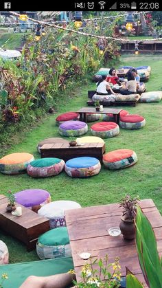 a group of people sitting on bean bag chairs in the middle of a lawn area