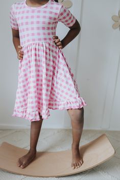 Be a fashion trendsetter in this PINKNIC GINGHAM DREAM RUFFLE DRESS! This fun and flirty dress is the perfect mix of style and comfort – it looks just as good twirling at a picnic as it does at a party! Featuring pink gingham fabric, dreamy ruffles, and a fit that'll have your girl glowing, any day spent in it will be a dream come true. Let her take center stage! Made from the softest and most breathable seasonal bamboo viscose material, your babe won't want to take this off! Designed for all th At A Party, Gingham Fabric, Flirty Dresses, Cap Sleeve Top, A Dream Come True, Bubble Romper, Pink Gingham, A Picnic, Your Girl