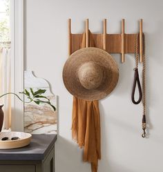 a hat hanging on the wall next to a pair of scissors and a wooden hat rack