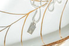 This dainty dog tag necklace can be personalized to make a special gift for her. Choose upper or lower case letter and choose the font. This necklace features - a sterling silver mini dog tag charm - engraving with a letter and font of your choice - a mini ball chain with lobster clasp - lengths from 16-20 inches Your new necklace will arrive in a gift box. To see our full line of jewelry, please visit http://www.austindowntoearth.etsy.com Silver Charm Necklace With Rectangular Pendant And Initials, Minimalist Silver Dog Tag Charm Necklace, Minimalist Dog Tag Charm Necklace As Gift, Minimalist Dog Tag Charm Necklace For Gift, Silver Dog Tag Necklace With Name, Silver Letter Necklace, Letter Necklace Silver, Tiny Dog, Special Gifts For Her