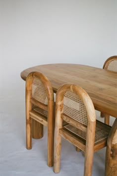 a wooden table with chairs around it on a white floored room background and the wall in the background