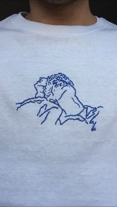 a man wearing a white tshirt with a blue graphic on it