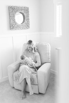 a woman sitting in a chair holding a baby