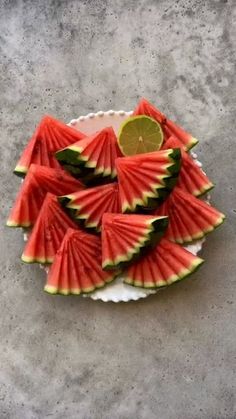 slices of watermelon arranged on a plate with a lime wedge in the middle