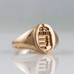 a gold signet ring with a coat of arms on it